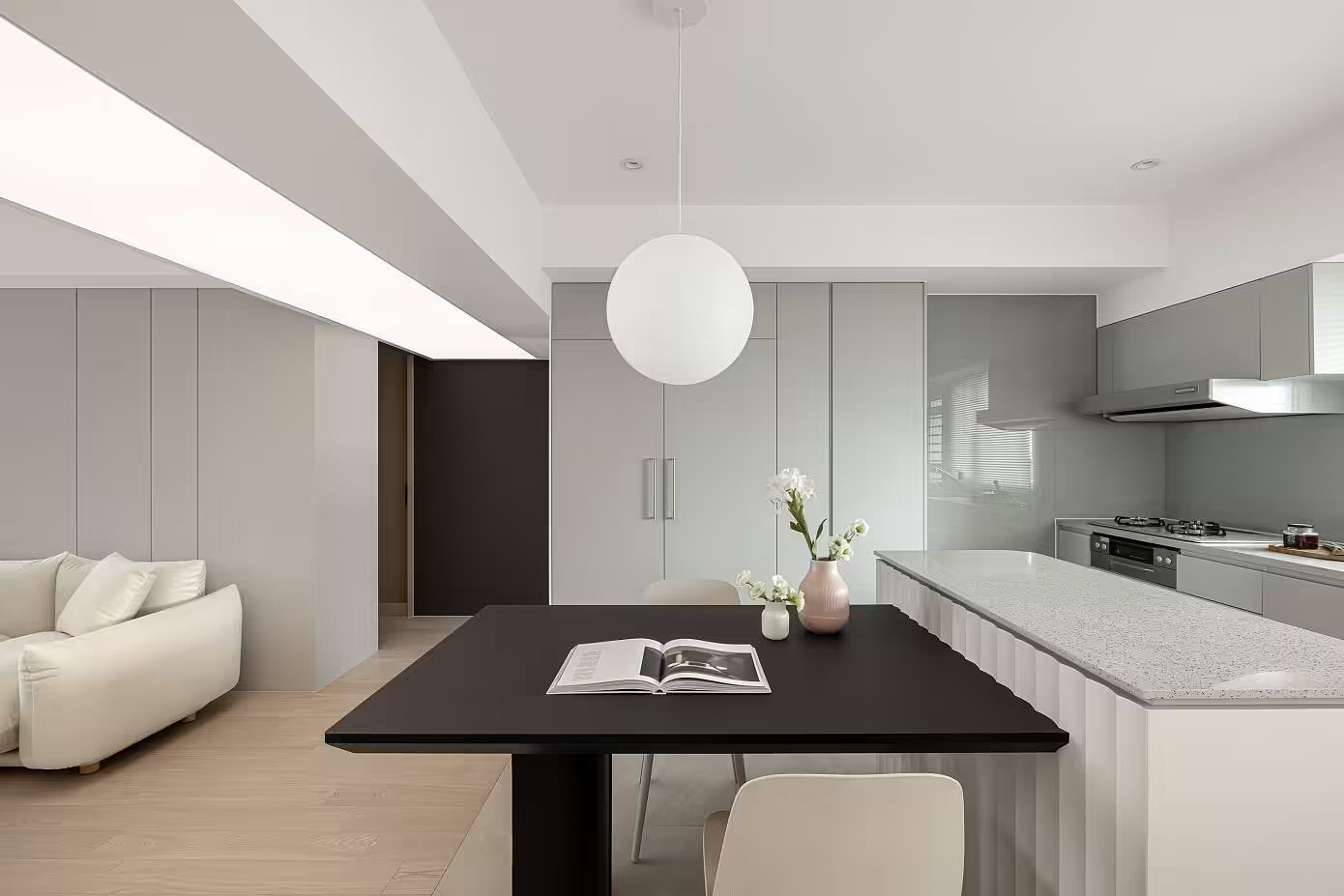 Phòng bếp và khu vực ăn uống được bố trí ở góc trái phòng khách, sử dụng gạch lát nền phân vùng với sàn gỗ. Bếp thiết kế đơn giản nhưng tiện nghi với bề mặt nội thất sáng bóng cùng hệ thống hút mùi hiện đại.