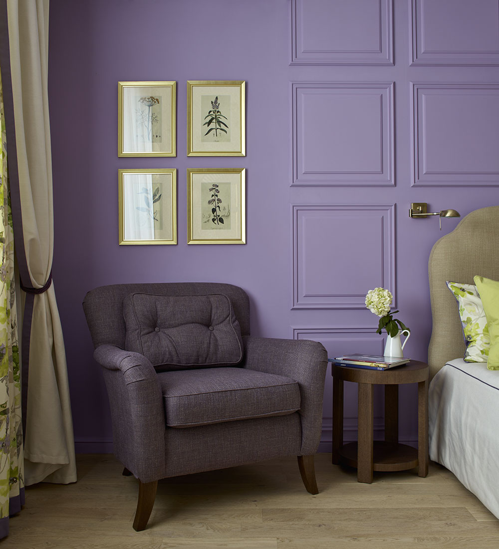 Tại góc phải giường ngủ, NTK bố trí bàn nước gỗ và chiếc ghế bành màu tím đậm để bà chủ đọc sách thư giãn. Trên tường, bộ 4 bức tranh chủ đề hoa cỏ rất xinh yêu. 