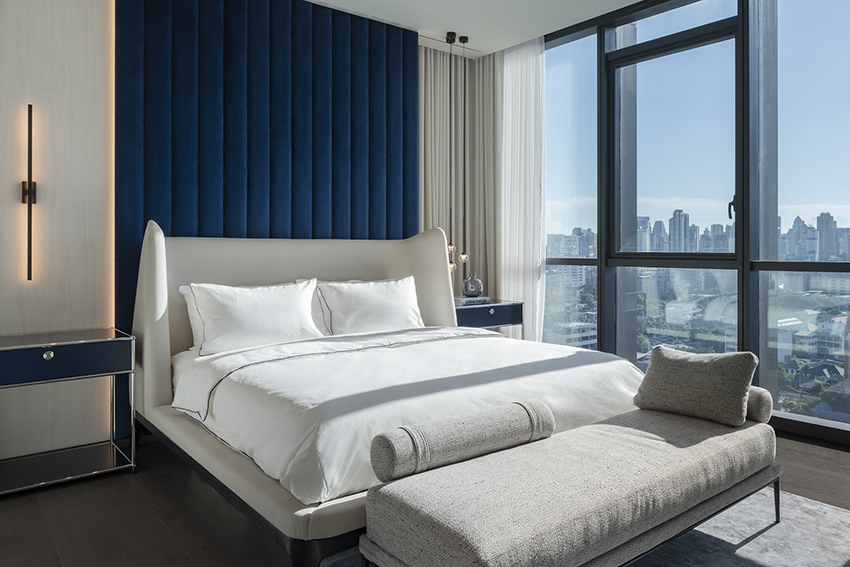 Phòng ngủ thứ hai lại sử dụng gam màu xanh lam đậm để làm điểm nhấn cho bức tường đầu giường, tone sur tone với táp đầu giường được bố trí cân xứng hai bên.