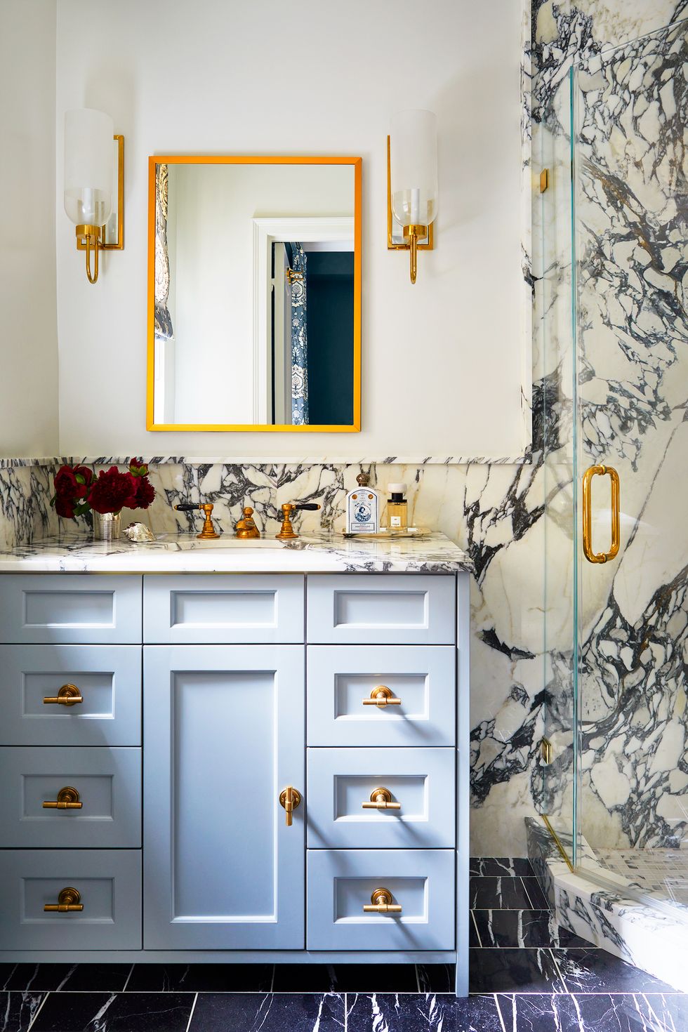 NTK nội thất đã làm nổi bật đường vân màu xanh lam đậm trên bề mặt đá cẩm thạch với màu xanh lam nhạt trên tủ vanity, kết hợp các chi tiết mạ vàng đồng sang chảnh.