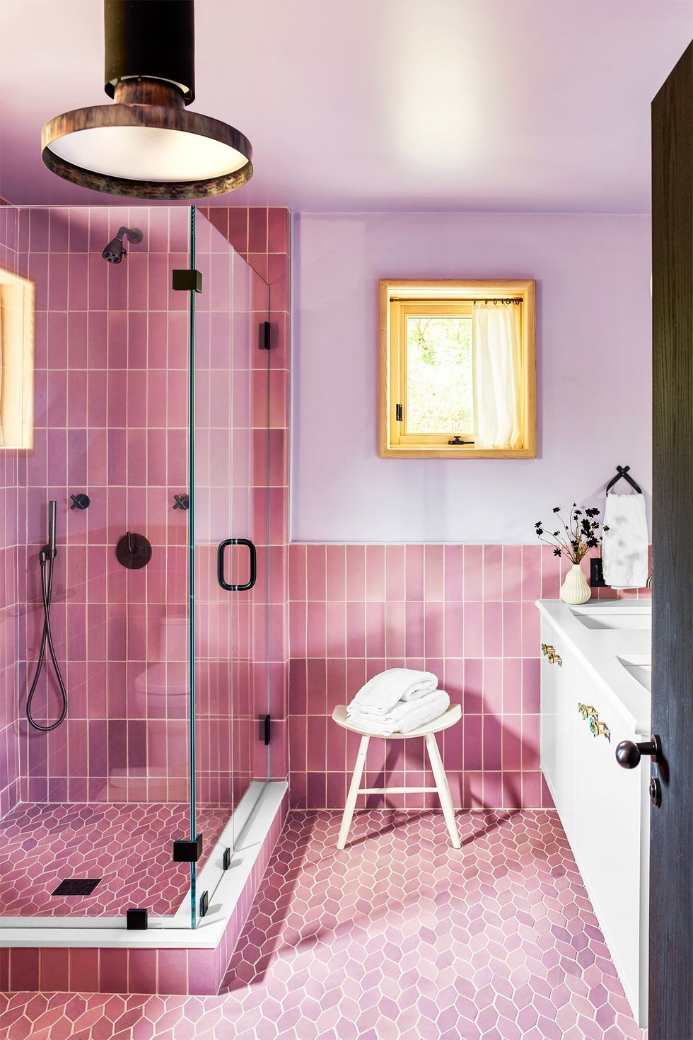 Phòng tắm nhỏ nhưng bắt mắt nhờ sự 'sánh đôi' của màu hồng - tím. Thêm vào đó là sự kết hợp giữa gạch thẻ dọc ốp tường và gạch hình chiếc lá cách điệu lát nền đẹp mắt.