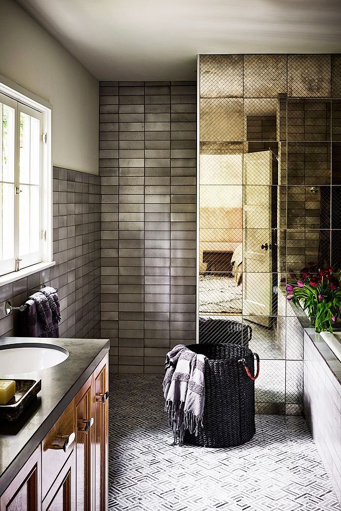 Sự kết hợp giữa những viên gạch zellige màu bạc ốp tường với những viên gạch tráng gương hình vuông mang lại cho phòng tắm một cái nhìn vừa độc lạ vừa có chút gì đó bí ẩn.