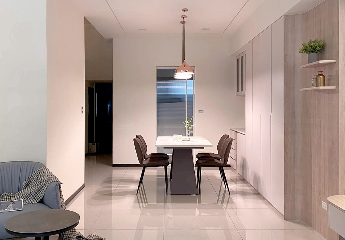 Góc trái phòng khách là khu vực ăn uống được thiết kế mở, sàn gạch sáng bóng xuyên suốt tầng 1. Phòng bếp được phân vùng với phòng ăn bằng cửa trượt kính mờ.