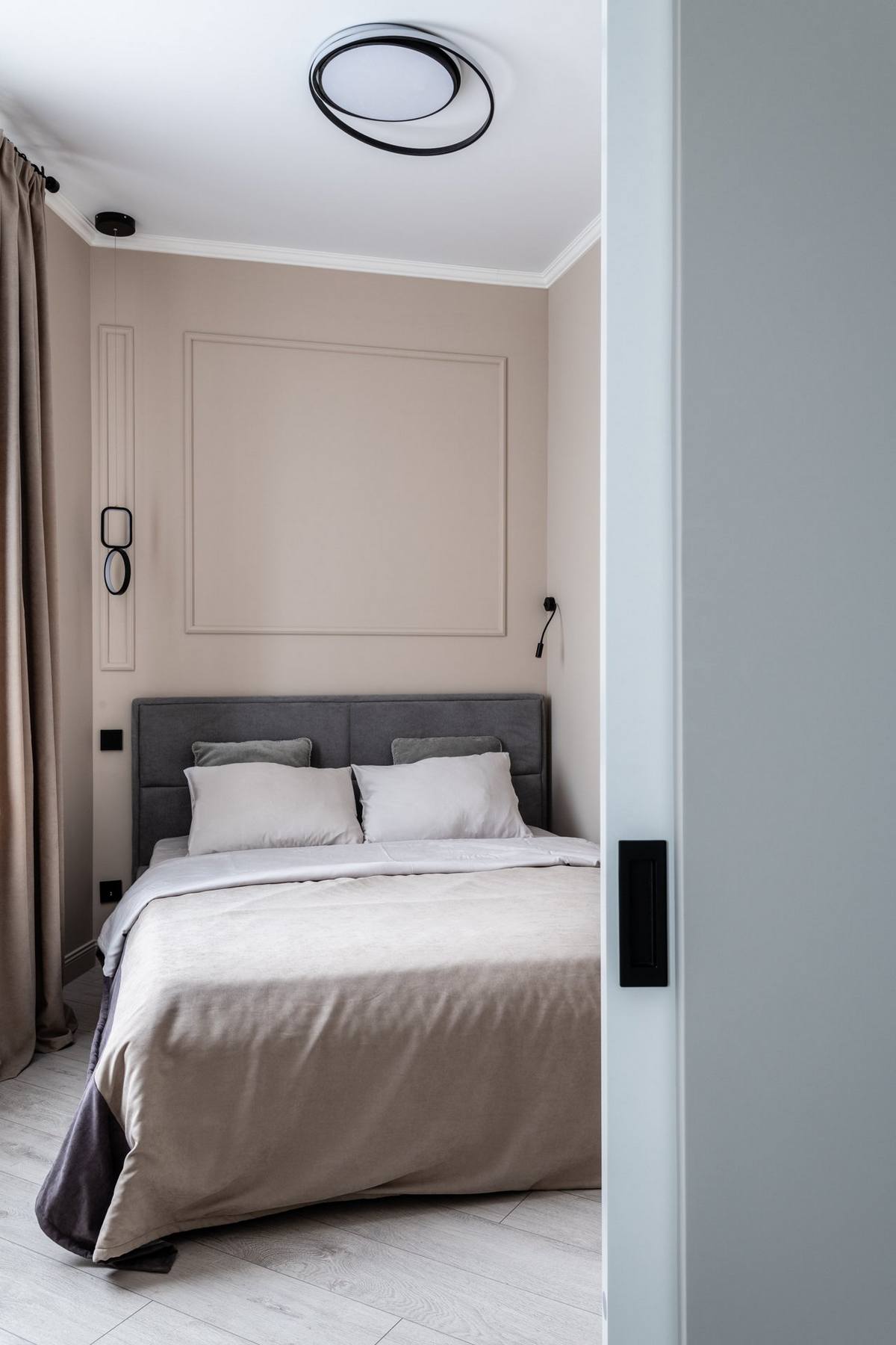 Khu vực phòng ngủ được bố trí riêng biệt với cánh cửa trượt tiện lợi, tường sơn màu be ấm áp, tương phản với trần nhà màu trắng cho cảm giác cao thoáng.