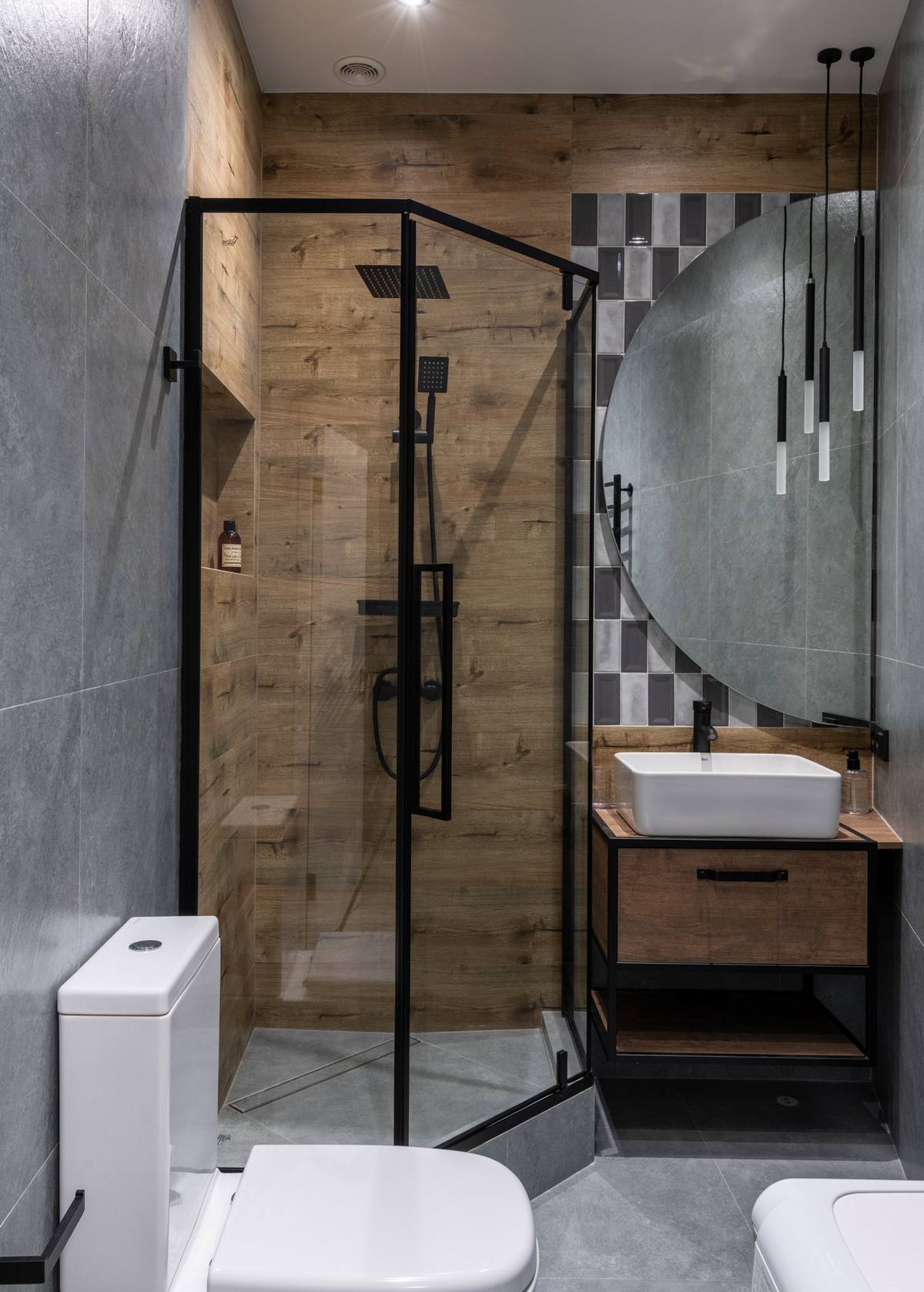 Phòng tắm, nhà vệ sinh nhỏ gọn nhưng vẫn 'chất' nhờ màu xám của gạch và sắc nâu ấm áp của gỗ. Tấm gương hình bán nguyệt cũng là điểm sáng cho phòng tắm nhỏ.