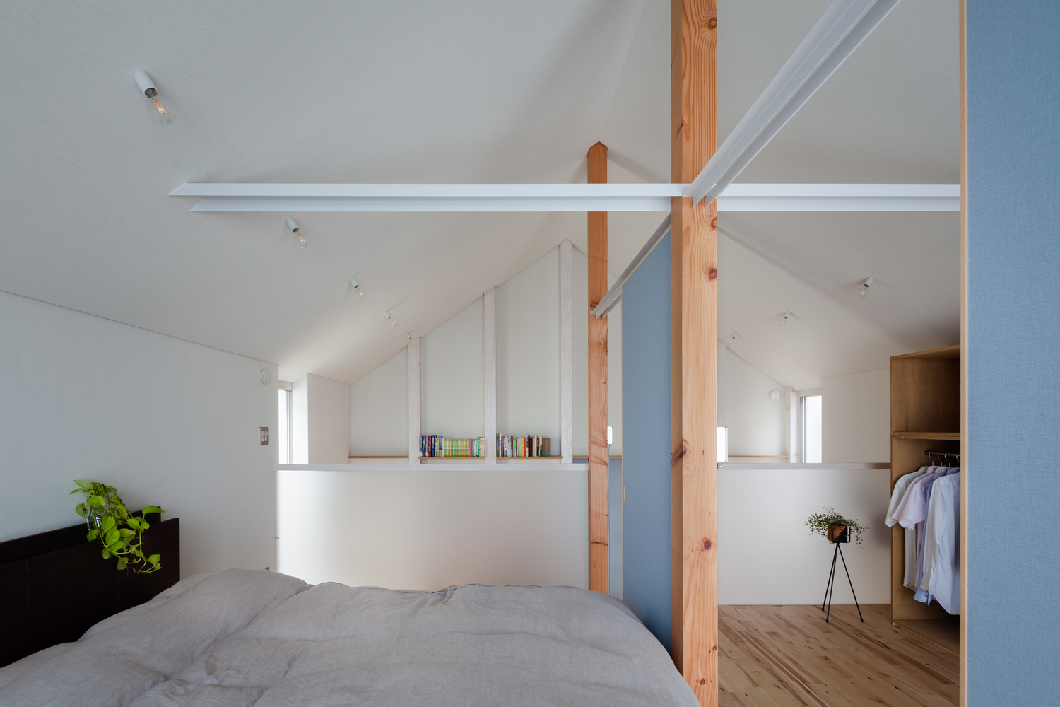 Phòng ngủ thiết kế tối giản theo phong cách của người Nhật Bản, trần nhà sơn màu trắng cho cảm giác cao thoáng. Phòng thay đồ và phòng ngủ phân vùng bằng cửa trượt màu xanh lam nhạt.