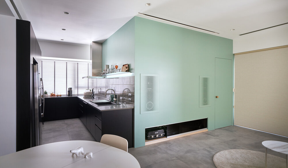 Phòng bếp gọn gàng với tone màu đen cho cảm giác vừa sang trọng vừa sạch sẽ, đồng thời tạo sự tương phản với sắc xanh bạc hà tươi mát của phòng ngủ kế bên. 