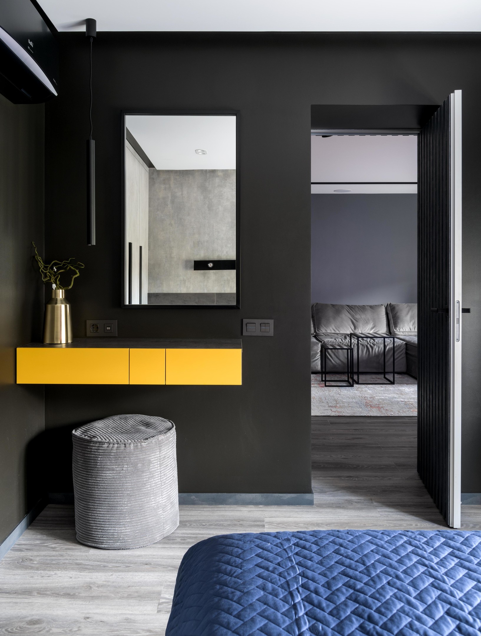 Thay vì chiếc bàn phấn chiếm khá nhiều diện tích, NTK nội thất chỉ bổ sung một chiếc bàn kết hợp tủ lưu trữ gắn tường với sắc vàng nổi bật trên phông nền đen bí ẩn.