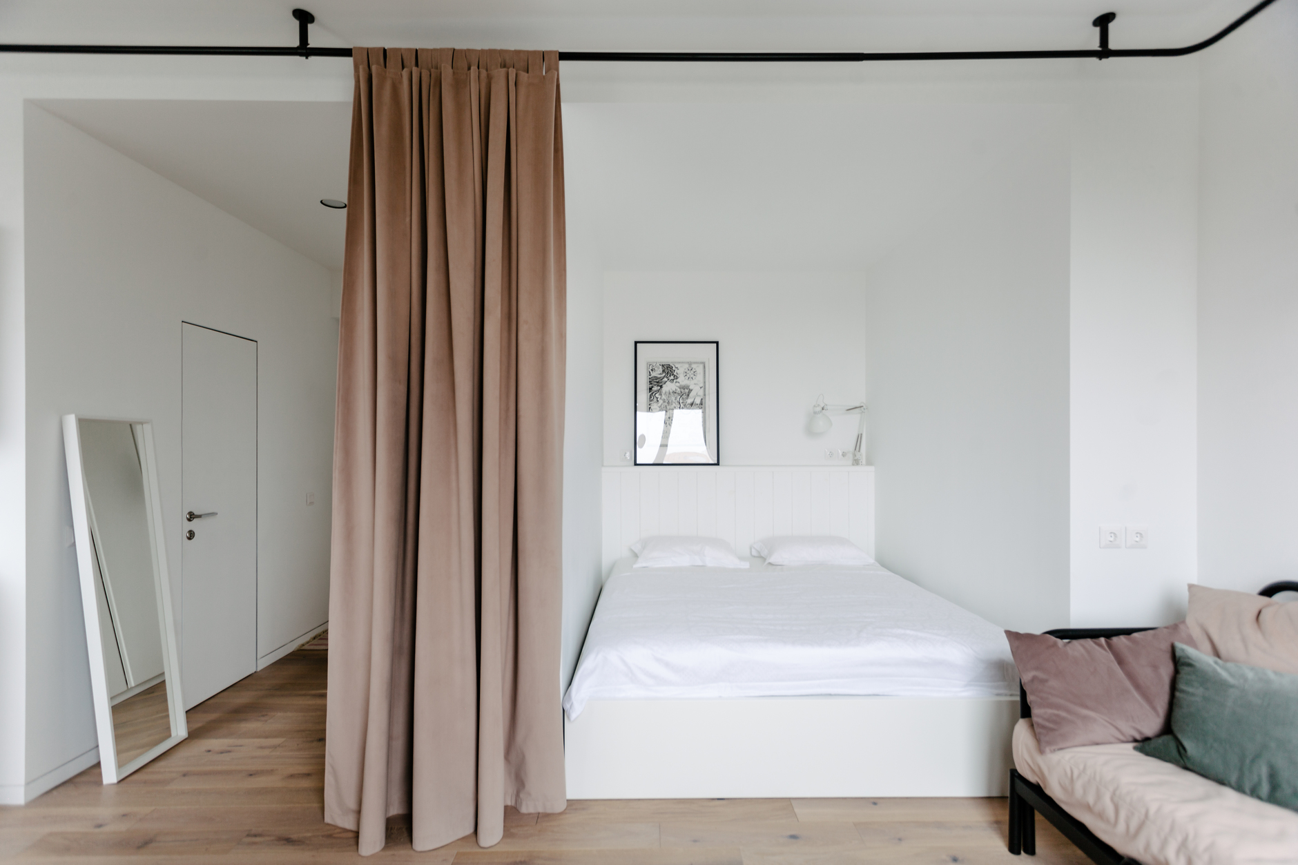 Do đặc điểm căn hộ studio là không có phòng ngủ riêng biệt nên Boris Denisyuk đã chọn hốc tường để bố trí phòng ngủ, nội thất tối giản với gam màu trắng, bổ sung rèm che bằng vải dày dặn để thuận tiện khi sử dụng. 