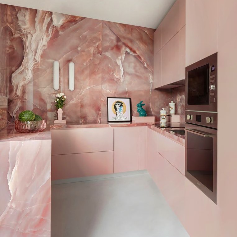 Phòng bếp dành cho những cô nàng yêu thích sự ngọt ngào bởi sắc hồng phấn nhẹ nhàng ở cả hệ thống tủ lưu trữ, mặt bàn bếp và toàn bộ backsplash ốp đá siêu đẹp.