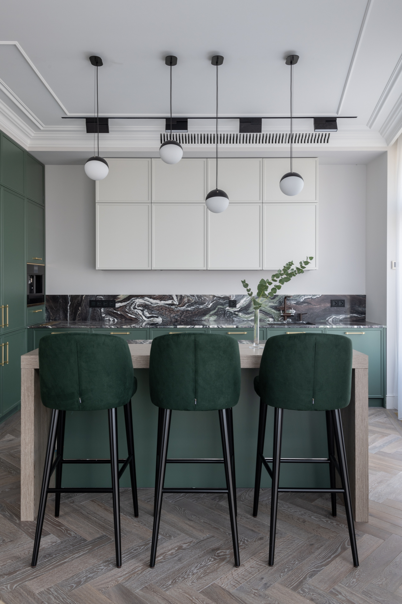 Sự kết hợp giữa gam màu xanh ngọc lục bảo của tủ bếp, bộ ghế ăn với backsplash ốp đá cẩm thạch hoa văn xám đậm tạo cho phòng bếp vẻ đẹp thời trang, sang trọng.