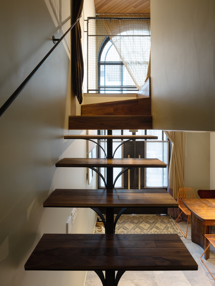 Cầu thang gỗ thiết kế không tay vịn dẫn lối từ phòng bếp lên khu vực chuyển tiếp. Giải pháp loại bỏ phần tay vịn cho không gian thông thoáng hơn, tuy nhiên cần lưu ý khi nhà có trẻ nhỏ.