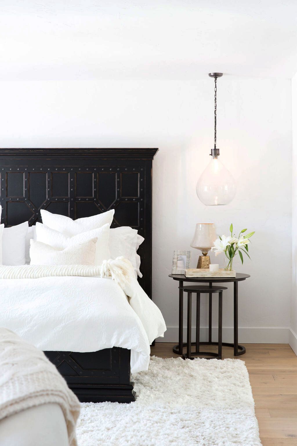 Khung giường màu đen vững chãi, bộ chăn ga gối màu trắng sạch sẽ kết hợp cùng đèn thả trần chiếu sáng tạo cái nhìn tươi mới và ấm áp cho không gian thư giãn.