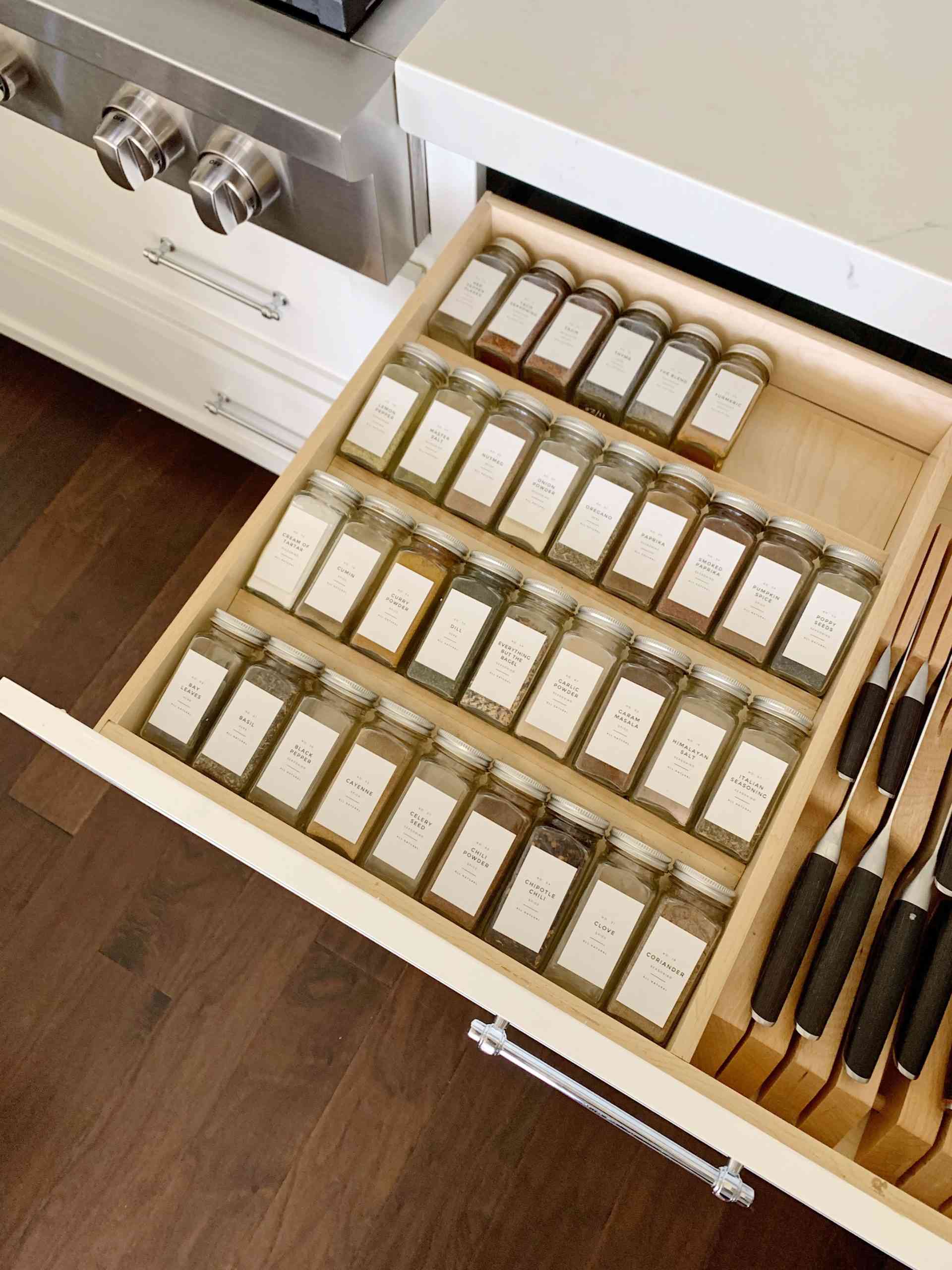 Chọn một ngăn kéo tủ dưới để sắp xếp các lọ gia vị gọn gàng, thêm một ngăn lưu trữ bộ dao làm bếp an toàn nữa!