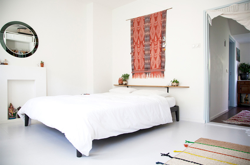 Phòng ngủ phối hợp giữa phong cách Scandinavian mà anh chồng yêu thích với những món đồ nội thất vintage trong bộ sưu tập của cô vợ. Tấm thảm treo tường là điểm nhấn nổi bật, mang lại sắc đỏ ấm áp cho không gian thư giãn.