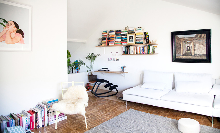 Phòng khách với ghế sofa không tay vịn, tone sur tone với nền tường tạo cảm giác như hòa lẫn vào không gian phủ đầy sắc trắng. Đây cũng là phong cách thiết kế tối giản mà người chồng yêu thích.