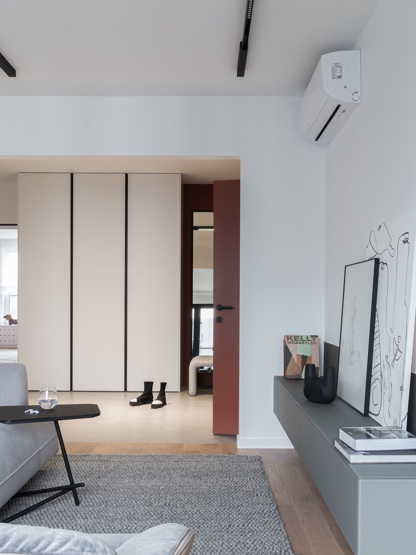 Lối vào căn hộ nhìn từ khu vực phòng khách với hệ thống tủ lưu trữ cao kịch trần giúp tối ưu hóa chiều cao trần, kết hợp tấm gương lớn giúp phản chiếu ánh sáng từ ô cửa lớn.