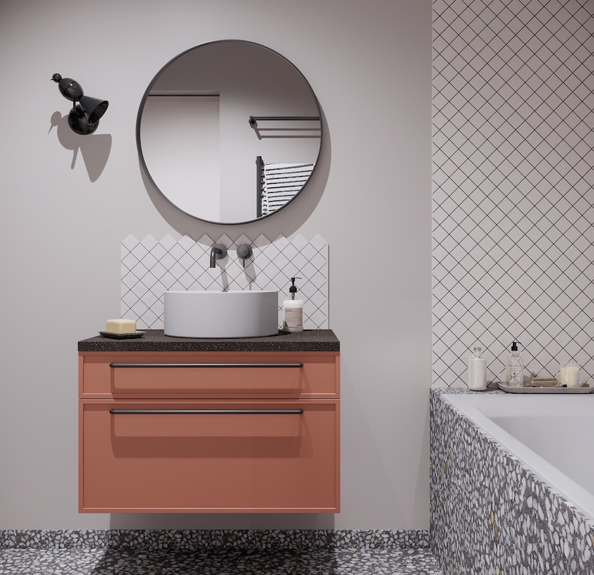 Phòng tắm với chiếc tủ vanity màu cam gạch bề mặt ốp đá cẩm thạch đen nổi bật trên phông nền màu xám. Gạch ốp tường và lát sàn có họa tiết khác nhau tạo nên sự sang trọng cho không gian nhỏ.