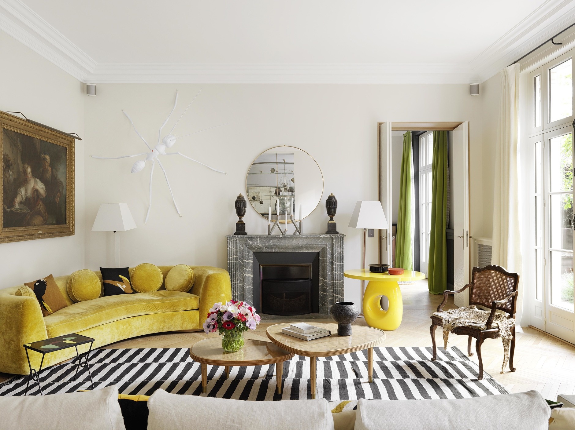 Bên cạnh những chi tiết mang nét cổ điển như tranh treo tường, ghế bành thì bàn nước đôi và sofa cong bọc nhung màu vàng mù tạt lại mang đến một hơi thở hiện đại.