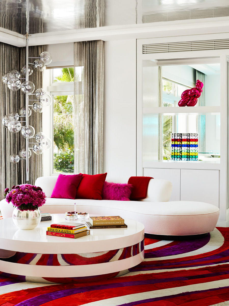 Đắm mình vào phòng khách rực rỡ sắc màu: Từ thảm trải sàn, gối tựa, lọ hoa,... tất cả đều ngập tràn tone màu hồng, tím, đỏ,... Nhờ vậy mà sofa cong màu trắng dịu dàng trở thành phông nền hoàn hảo hơn cả.