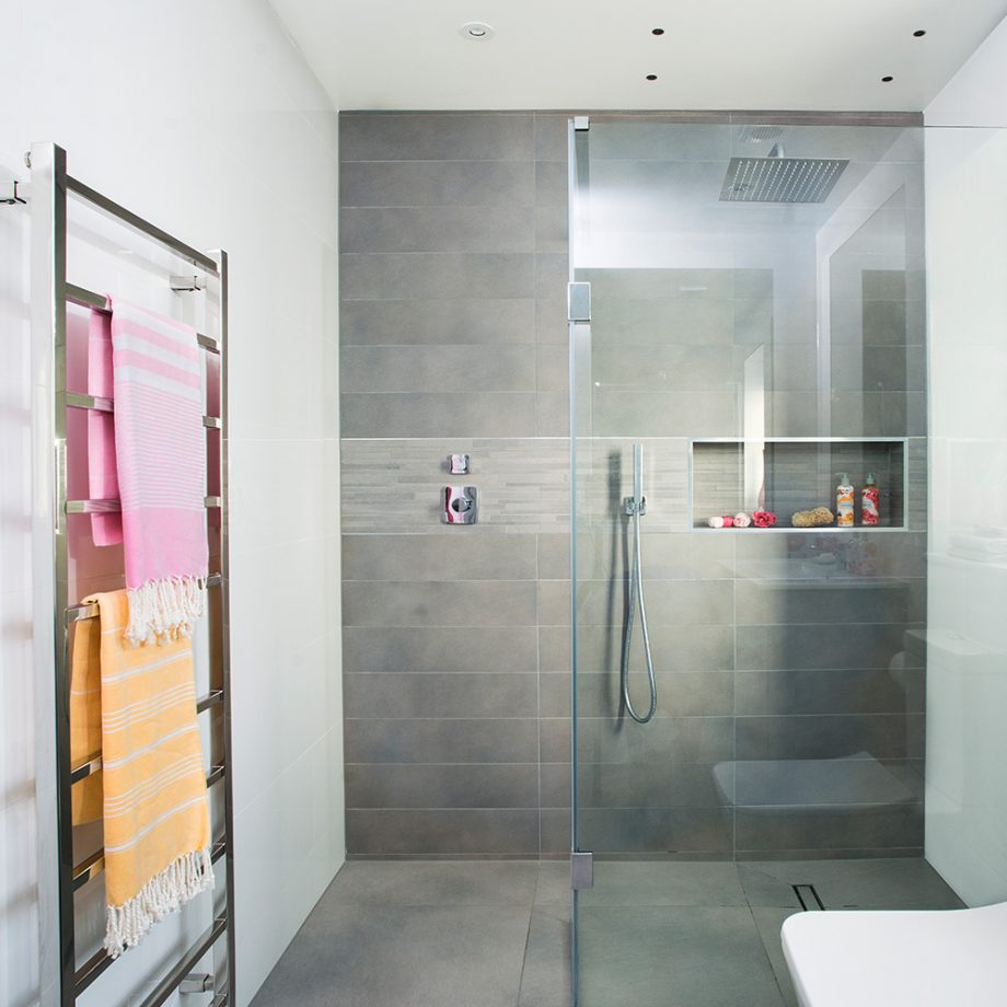 Gạch ốp tường và lát sàn phòng tắm sử dụng tone màu xám tự nhiên, gợi liên tưởng đến màu đá thô mộc.