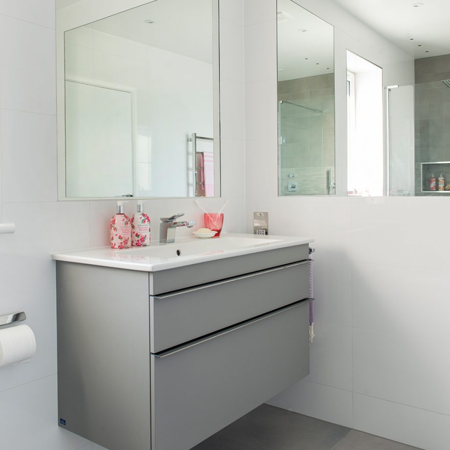 Khu vực bồn rửa tay ở góc tường được chủ nhân đầu tư một chiếc tủ vanity gắn tường tiện ích kết hợp 2 tấm gương soi cỡ lớn.