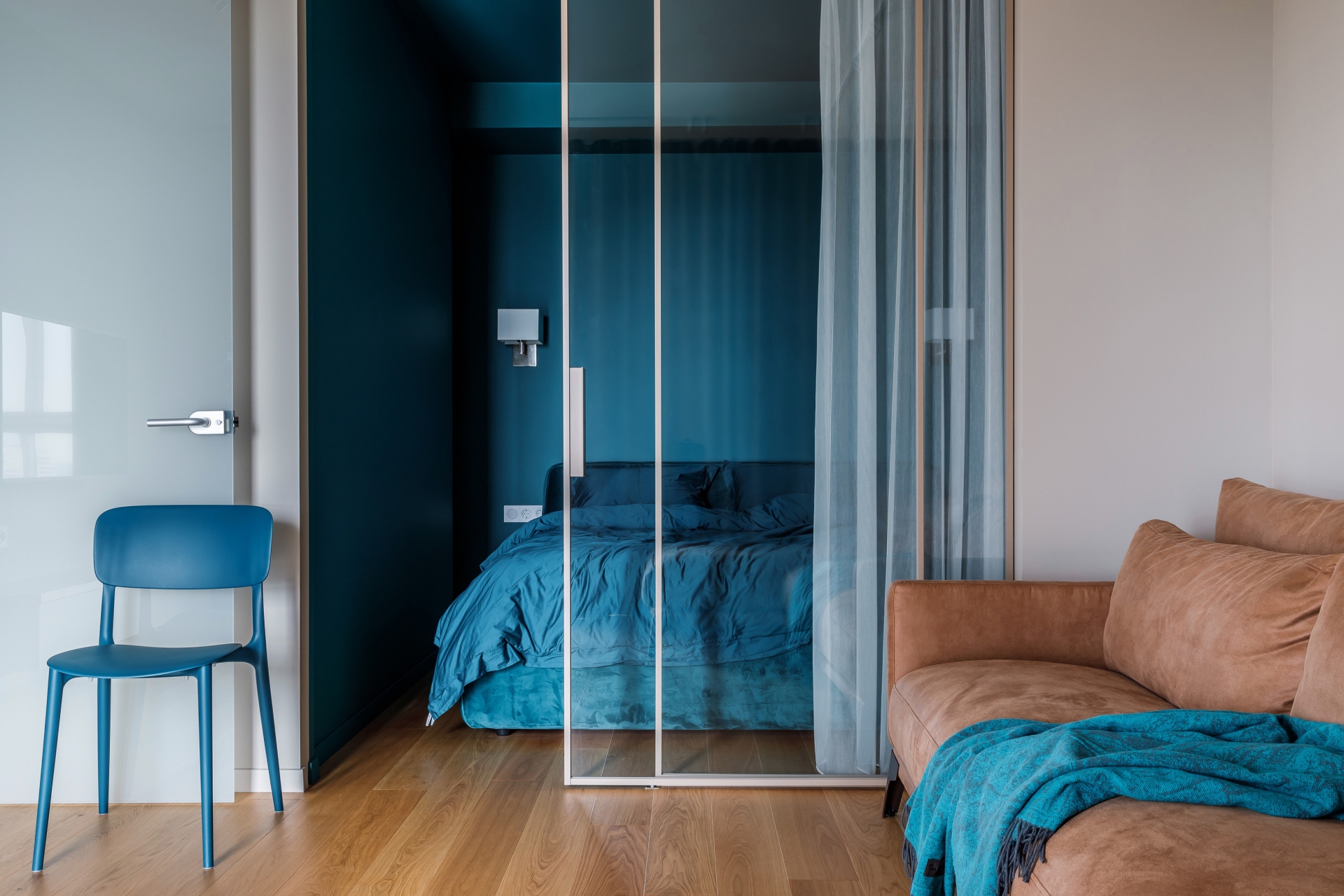 Phòng khách của căn hộ thiết kế đơn giản với chiếc ghế sofa module bọc da lộn màu nâu êm ái. 