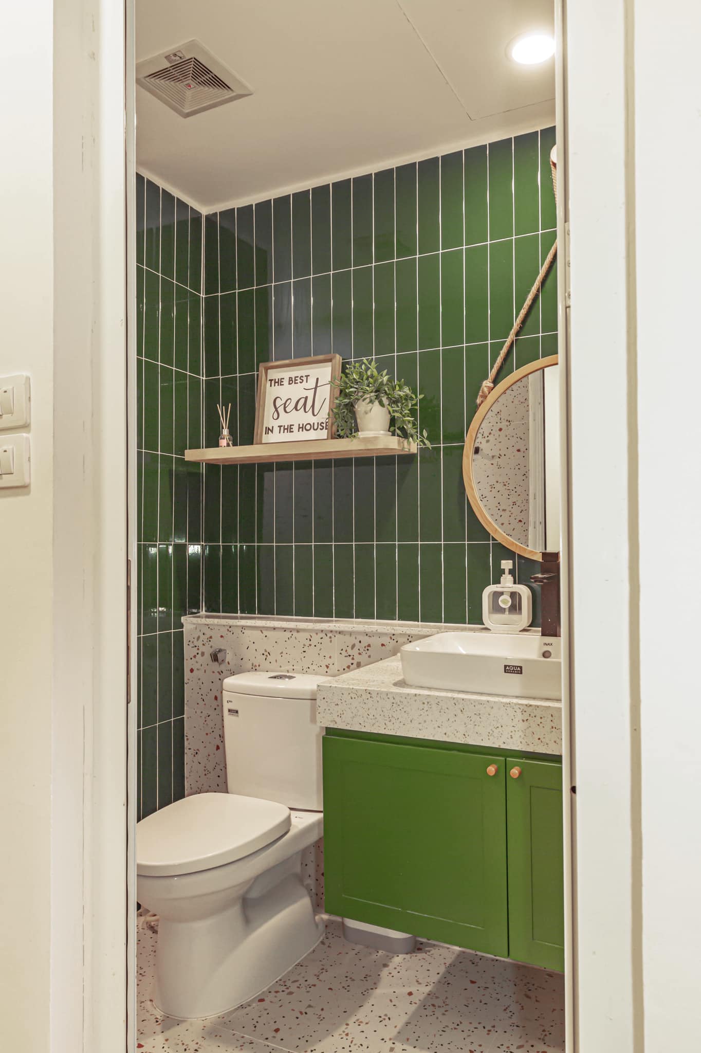 Phòng tắm đầu tiên chọn gam màu xanh lá cây tươi mới và xanh rêu đậm làm điểm nhấn giữa gạch ốp lát họa tiết terrazzo trẻ trung. 