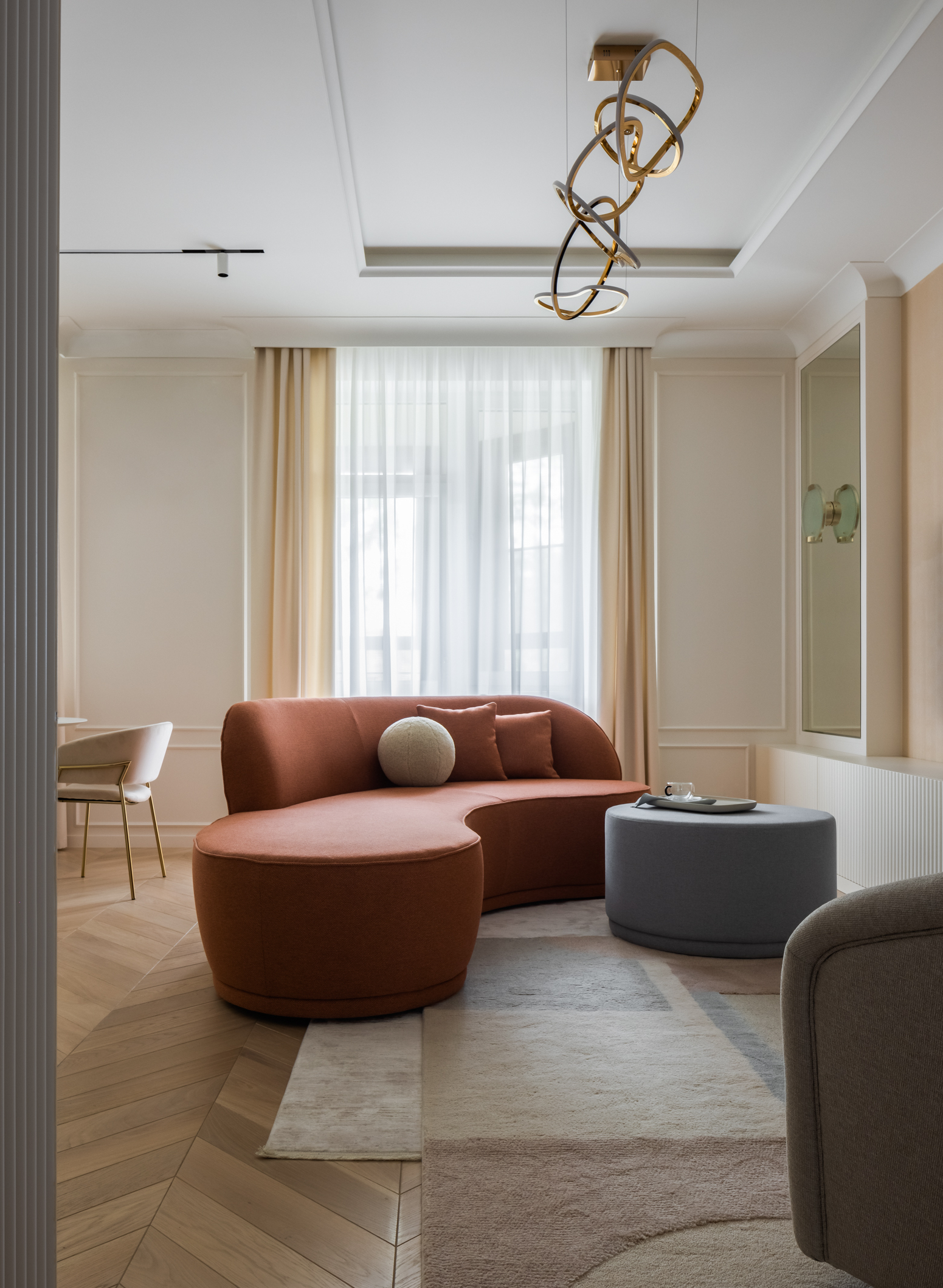 Phòng khách ấn tượng với bộ bàn nước và ghế sofa có đường cong mềm mại, đặt gia công theo bản thiết kế của Olga. Sự kết hợp của màu gạch đất nung cùng xanh lam nhạt cho cảm giác vừa ấm áp vừa tươi mới.