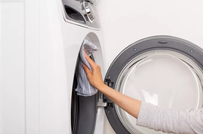 Khi chu trình hoàn tất, sử dụng một miếng vải mềm, thấm nước để lau khô xung quanh cửa máy giặt, gioăng mềm và cửa. 
