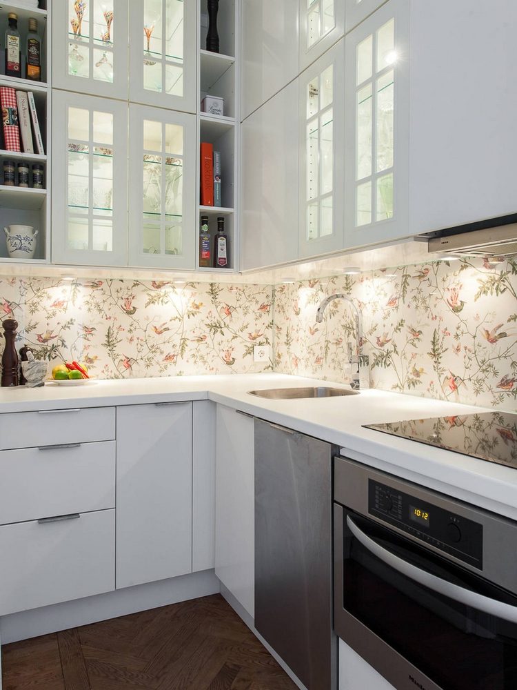 Kiểu thiết kế tủ kính chiều cao kịch trần được lặp lại tại phòng bếp nhưng với phiên bản mini dành cho tủ bếp trên. Hệ thống đèn gầm cũng giúp bếp nhỏ sáng sủa hơn.