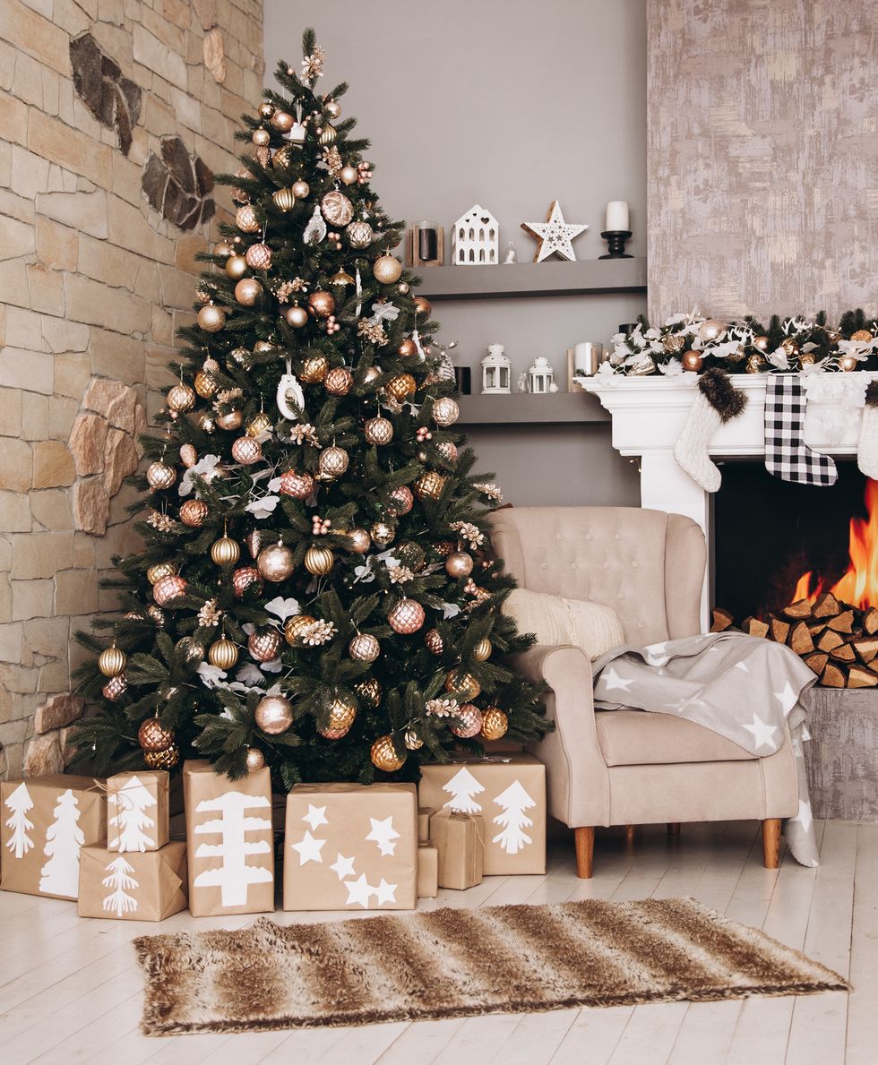 Mặc dù không gian phòng khách chỉ sử dụng tone màu trung tính như xám, be,... nhưng cây thông Noel vẫn rất nổi bật theo cách trang trí tone vàng đồng và be ấm.