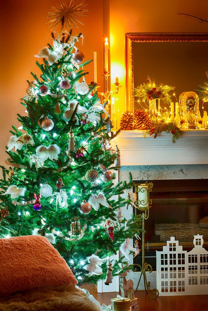 Màu xanh thẩm của cây thông Noel kết hợp với những phụ kiện màu bạc trở nên lấp lánh huyền ảo giữa không gian bao phủ sắc vàng ấm áp của nến và đèn điện.