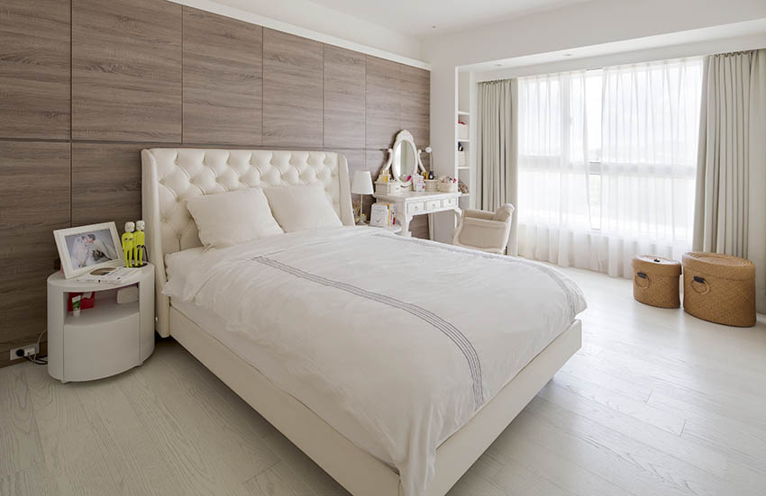 Phòng ngủ của bố mẹ thiết kế ấm áp với tone màu trắng kem kết hợp nội thất gỗ. Góc trái giường ngủ là táp đầu giường với ảnh cưới ngọt ngào. Góc phải là bàn phấn trang điểm phong cách châu Âu cho mẹ.