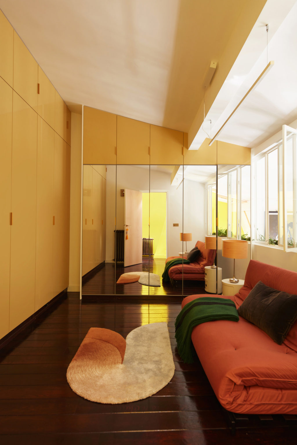 Tầng 2 bố trí một phòng khách phụ với ghế ngồi màu cam gạch ấm cúng và loại bỏ bàn nước để tạo lối đi rộng rãi. Đây cũng được dùng như phòng thư giãn, phòng ngủ cho khách vì chiếc ghế có thể mở rộng thành chiếc nệm êm ái.