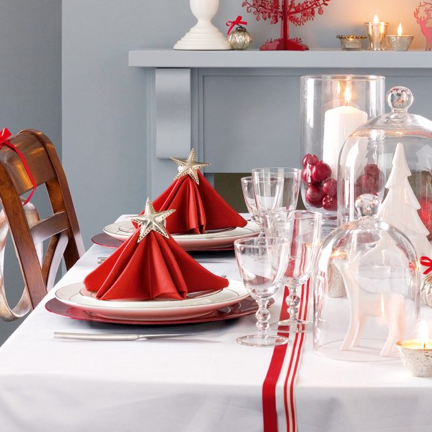 Bàn ăn thiết kế với tone màu trắng - đỏ chủ đạo đúng chủ đề Giáng sinh, và nó sẽ càng ấn tượng hơn với những cây thông Noel làm bằng khăn ăn màu đỏ nổi bật ngôi sao trên đỉnh chóp.