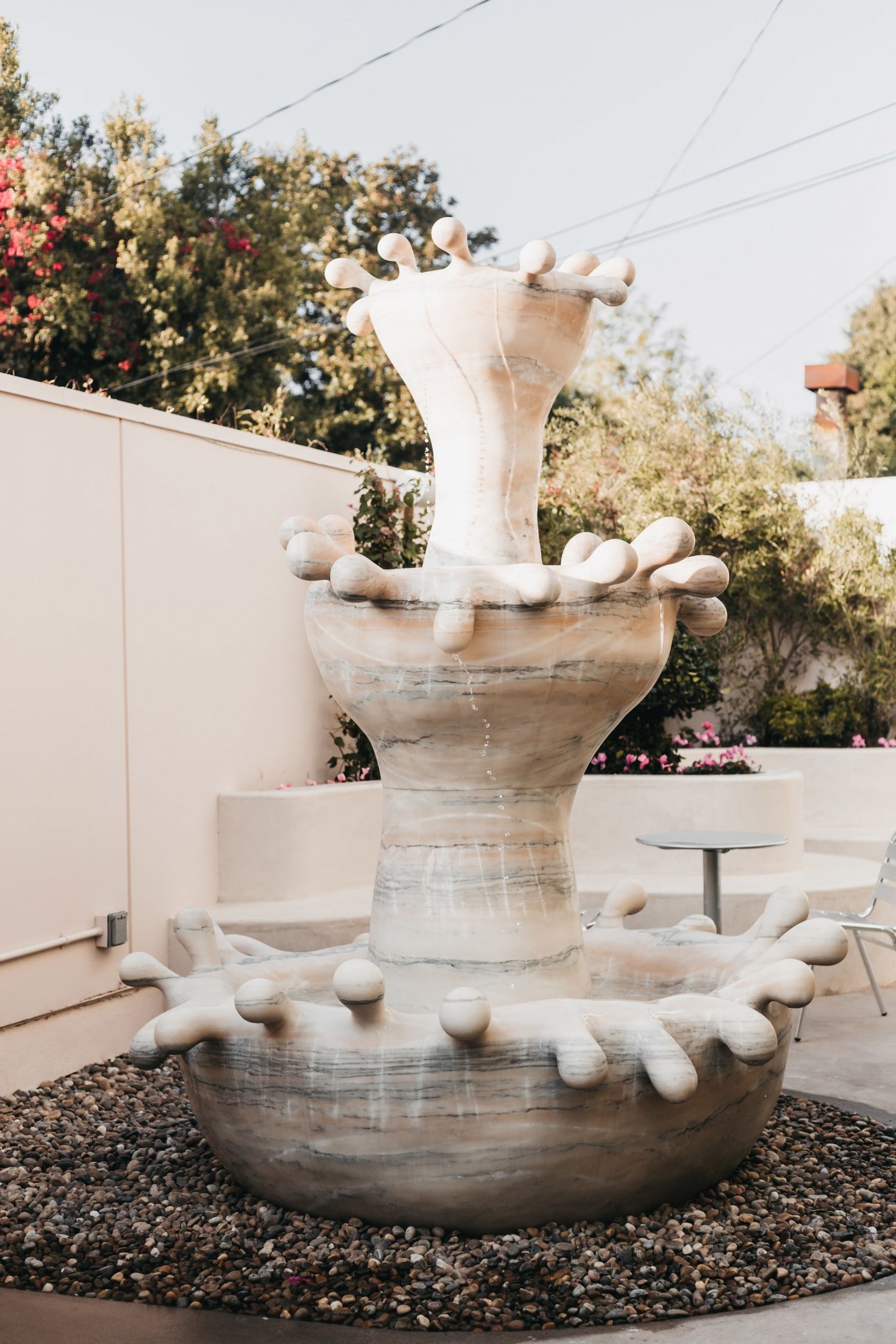 Đài phun nước bằng đá cẩm thạch với vẻ đẹp siêu thực ở khu vực sân trong, được tạo ra bởi bộ đôi sáng tạo The Haas Brothers. 