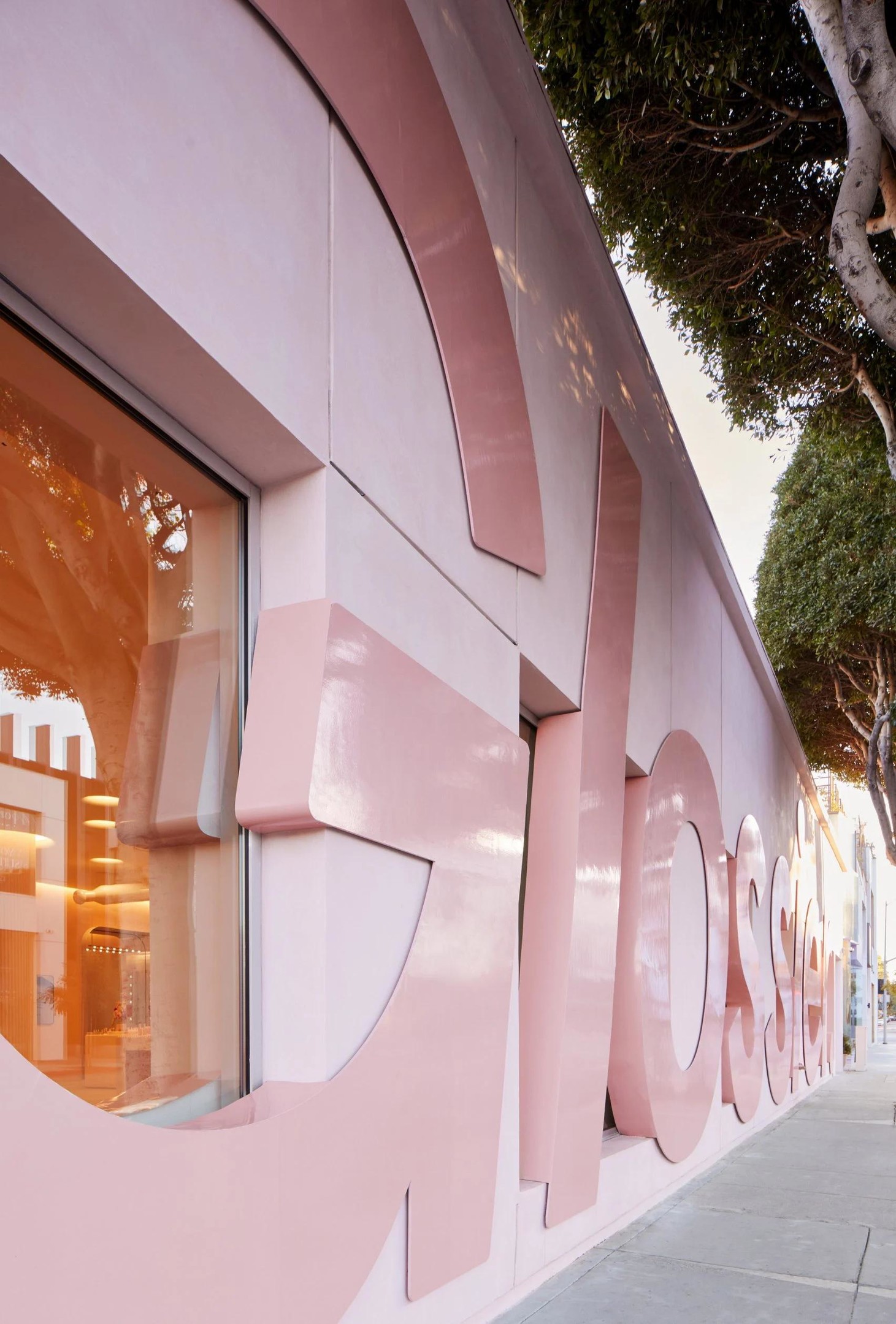 Cửa hàng thu hút sự chú ý của người qua đường với mặt tiền màu hồng phấn với dòng chữ GLOSSIER bóng loáng. 