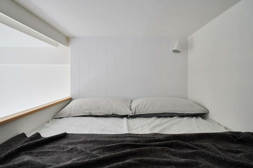 Phòng ngủ tối giản với duy nhất 2 tone màu trắng - đen cổ điển, không gian vừa đủ cho một chiếc giường êm ái, thêm đèn gắn tường tiện lợi.