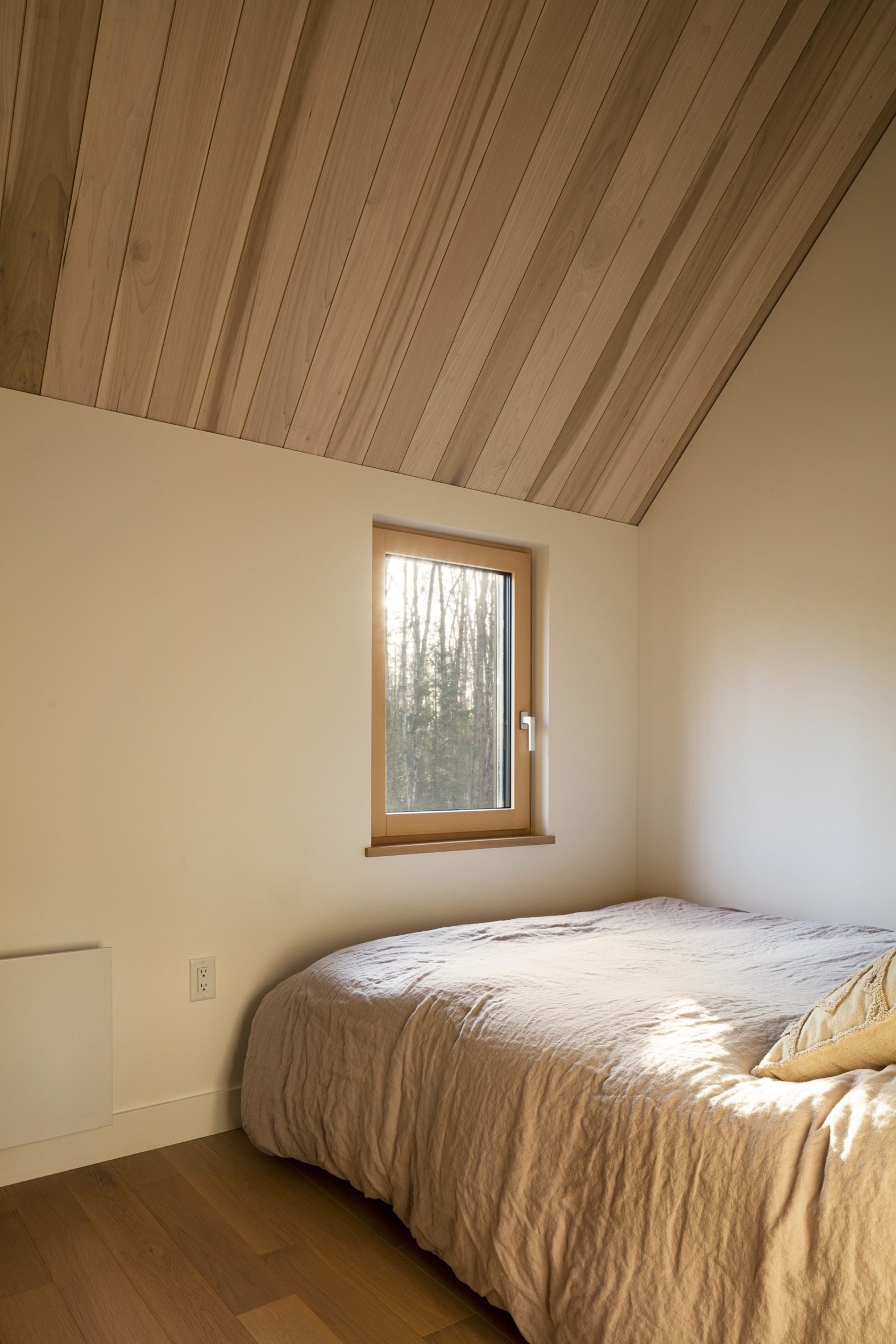 Một phòng ngủ khách cũng được thiết kế tối giản cả về nội thất lẫn màu sắc, tôn lên vẻ đẹp của khung cảnh thiên nhiên thay đổi 4 mùa bên ngoài ô cửa nhỏ.
