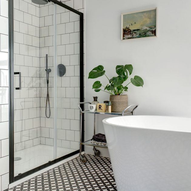 Buồng tắm đứng vòi sen phân vùng với bồn tắm nằm bằng cửa kính trượt trong suốt.