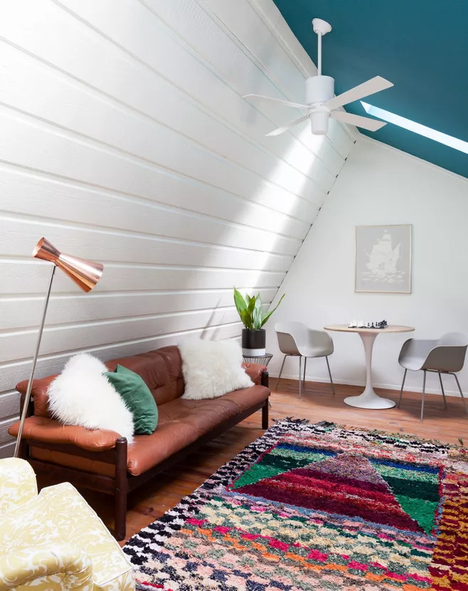 Phòng khách trên tầng áp mái ở vị trí khá 'hóc búa' nhưng NTK nội thất vẫn khéo léo tạo cảm giác cho nó rộng rãi hơn so với diện tích thật nhờ sự tương phản giữa tường trắng, trần xanh lam và cửa sổ mái tạo nên góc nhỏ thi vị.