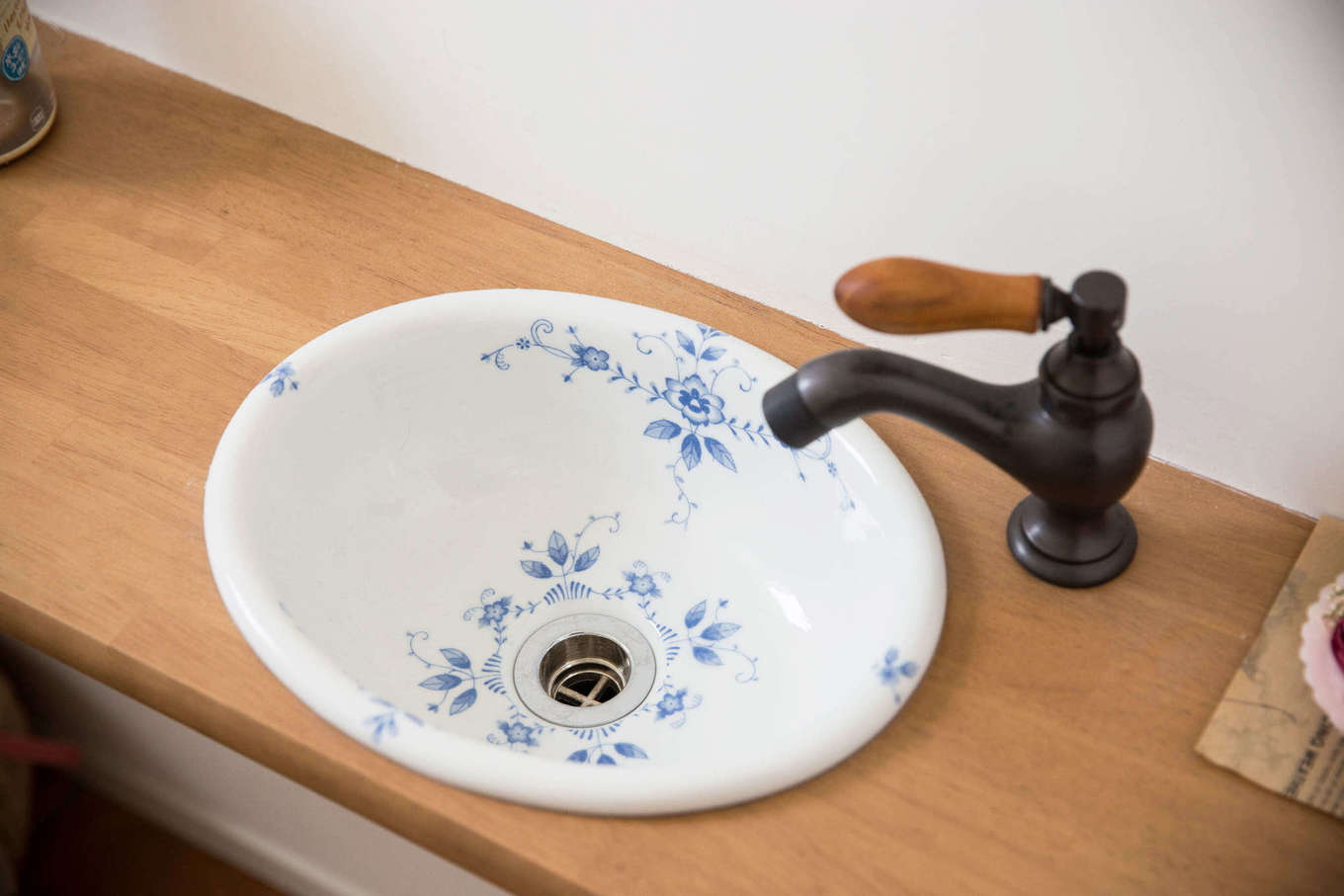 Bồn rửa tay trong phòng tắm được thiết kế với vòi nước kiểu cổ điển, bồn sứ trắng với hoa văn màu xanh lam, tinh tế đến từng chi tiết nhỏ.
