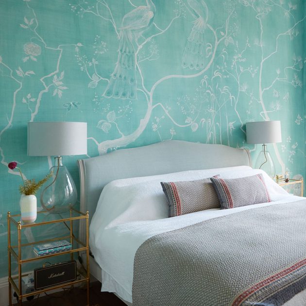 Phòng ngủ nhẹ nhàng với giấy dán tường tone màu xanh ngọc lam, bộ đôi đèn bàn với thân đèn bằng thủy tinh trong suốt, vừa lung linh huyền ảo về đêm vừa không hề 'lấn át' vẻ đẹp của hoa văn trên tường.
