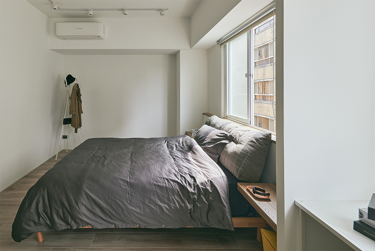 Phòng ngủ lấy cảm hứng từ phong cách tối giản Nhật Bản với rất ít nội thất, chỉ có giường, táp đầu giường gắn tường và kệ treo áo khoác, mũ nón, túi xách,... ở góc phòng.