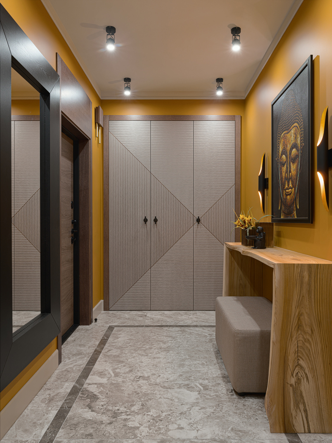 Cùng là vật liệu gỗ nhưng khu vực cánh cửa ra vào, khung gương treo tường và chiếc bàn nhỏ gọn lại sử dụng 3 tone màu khác nhau gồm nâu, đen và vàng nhạt để giúp không gian trở nên sinh động hơn.