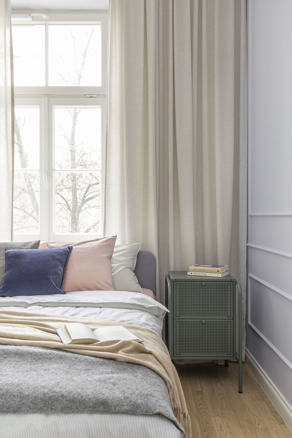 Cuối hành lang phòng khách là phòng ngủ của chủ nhân với thiết kế nhẹ nhàng, sử dụng các gam màu trung tính như trắng, xám, be, đặc biệt là sự nhấn nhá của sắc xanh lam, hồng phấn và xanh ô liu của táp đầu giường.