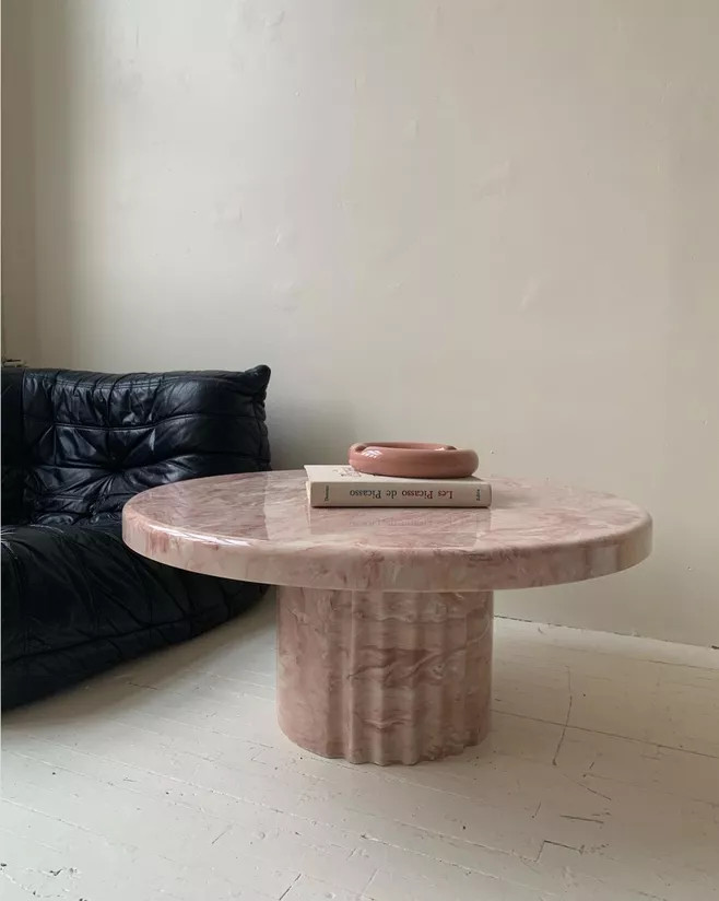Chúng tôi yêu thích thiết kế tối giản trong không gian này. Một chiếc ghế bọc da màu đen đơn giản nhưng êm ái, kết hợp chiếc bàn đá cẩm thạch sắc hồng hình trụ, mặt bàn tròn dày dặn cho vẻ đẹp vừa mềm mại vừa vững chãi.