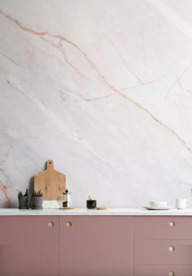 Thoạt nhìn, bạn sẽ nhìn phần đá ốp tường này có màu trắng bởi sự tương phản với tủ màu hồng đỗ. Tuy nhiên, nó là đá cẩm thạch gam hồng pastel nhẹ nhàng kết hợp những đường vân có màu sắc đậm hơn làm điểm nhấn tự nhiên.
