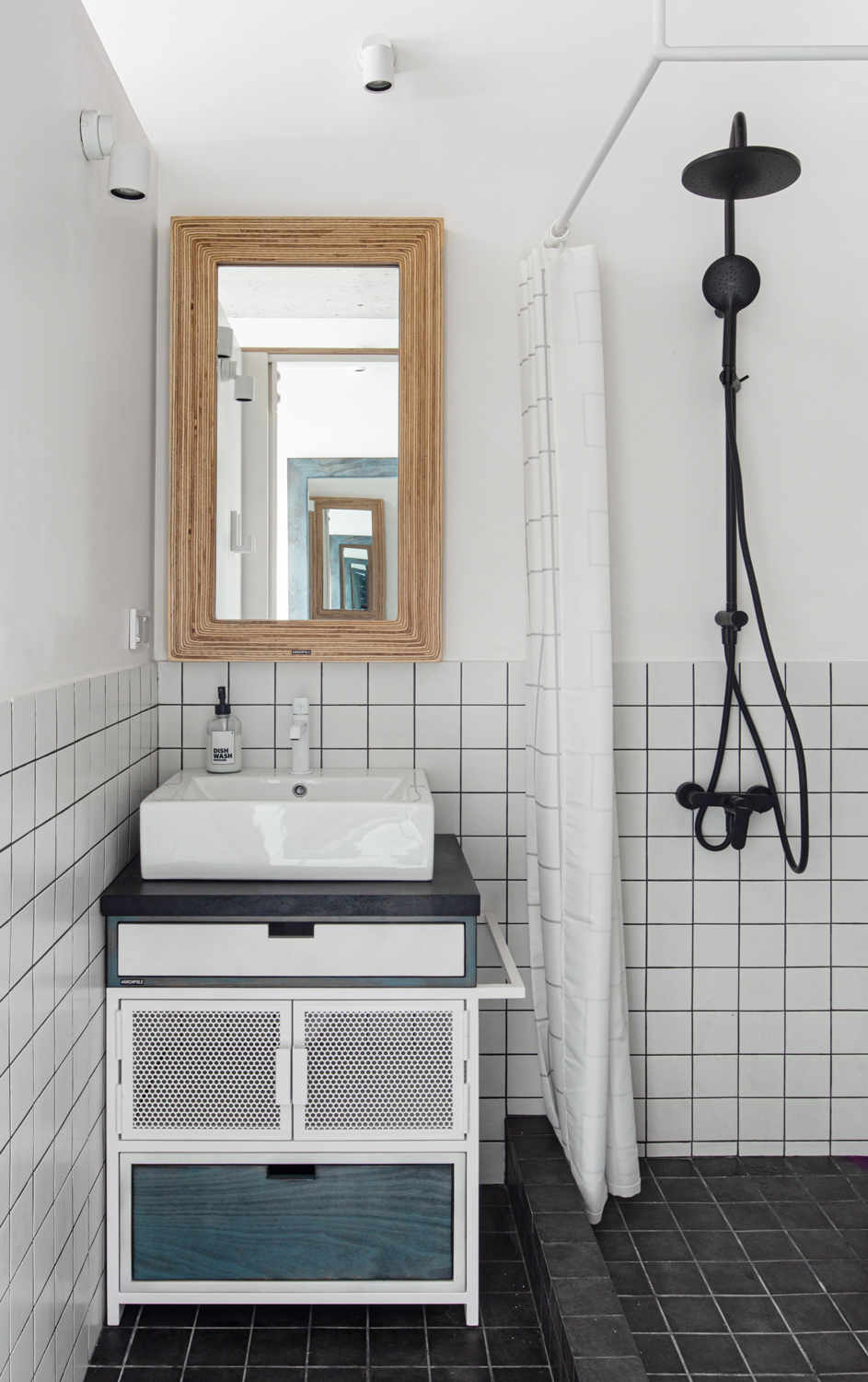 Phòng tắm gấy ấn tượng với sự tương phản của gạch ốp tường trắng và gạch lát sàn màu đen. 